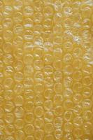 Packaging with air bubbles on a yellow background. Bubble wrap texture, packaging, air bubble film. Top view. Copy, empty space for text photo