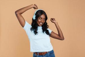 Smiling African woman dancing with headphones photo