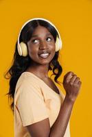 mujer africana feliz escuchando música en auriculares foto