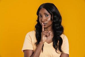 Confident African woman showing silence gesture to the camera photo