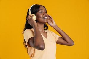 Happy African woman singing with headphones on photo