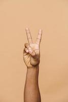 dedos masculinos africanos que muestran paz o victoria foto
