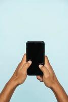 Man holds a phone screen to the camera with both hands photo