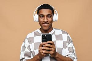 Pretty African man looking at the camera with headphones