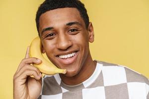 Portrait of smiling African man calls on banana photo