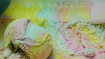 Regenbogeneis mit blauem Löffel geschöpft. Muster und Farben der Eiscremebeschaffenheit. video