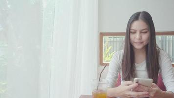 una mujer joven y hermosa está usando una tarjeta de crédito para comprar en línea en una cafetería video