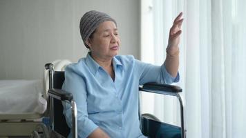 mulher de paciente de câncer asiático deprimido e sem esperança usando lenço na cabeça no hospital. video