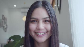 retrato de mulher jovem e bonita está sorrindo na cafeteria, câmera lenta video