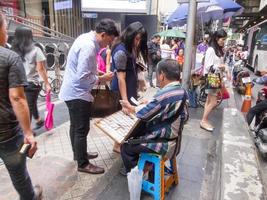 Silom BANGKOKTHAILAND16 AUGUST 2018  In the morning people Buying lottery tickets from most sellers will be visually impaired or otherwise physically disabled. on BANGKOKTHAILAND16 AUGUST 2018 photo