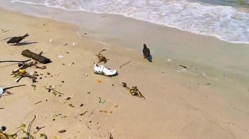 Stranded washed up garbage waste trash pollution on beach Brazil.