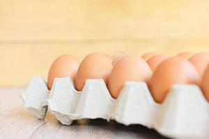 Eggs in egg box on wooden background Close up of raw chicken eggs organic food photo