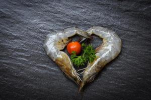 Mariscos dos camarones en forma de corazón langostinos crudos frescos sobre fondo oscuro