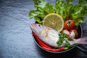 Seafood fish plate with herbs and spices lemon tomato chilli garlic parsley and vegetable ocean gourmet dinner photo