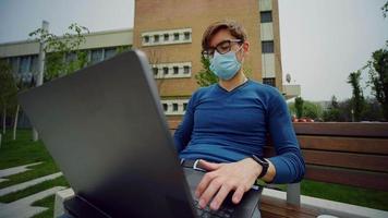 empleado caucásico usa máscara trabajando en un parque de la ciudad. video