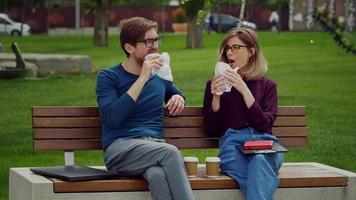 amigos tomando un bocadillo en un parque. video