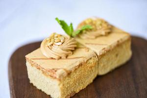 coffee cake delicious dessert with mint leaf and nuts topping on wooden photo