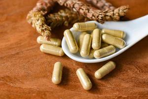 Herbal capsules from herbs healthy lifestyle - Herbal medicine extract from nature Non-toxic drug organic product on spoon and wild flower photo