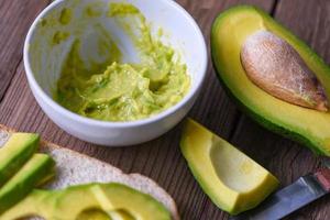 Fruits healthy food concept - Avocado sliced half and avocado dip mashed on bowl