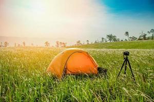 Tent area on hill mountain sunrise Landscape camping tents yellow on field in the forest with digital camera photo