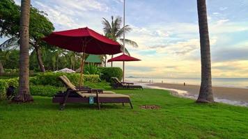 regenschirm mit stuhl mit seestrandhintergrund und sonnenaufgang am morgen - urlaubs- und urlaubskonzept video