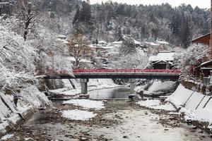 Nakabashi Bridge with snow fall and Miyakawa river in winter season . Landmark of Hida - Gifu - Takayama , Japan . Landscape view photo