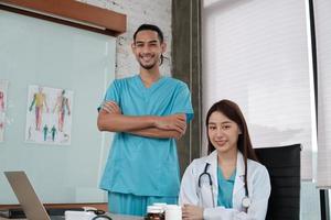 equipo de socios de atención médica, retrato de dos jóvenes médicos de origen asiático en uniforme con estetoscopio, sonriendo y mirando a cámara en la clínica, personas con experiencia en tratamiento profesional. foto