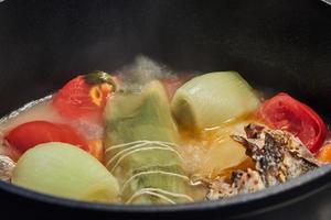 Vegetables boiling in saucepan with steam close-up