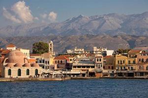 puerto de chania y mezquita de los jenízaros con montañas blancas al fondo. foto