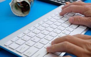 en un escritorio, un hombre de negocios está usando una computadora portátil, mientras que un hombre de negocios está trabajando en su oficina. trabajo independiente, vida estudiantil, e-learning, estudio, sitio web y tecnología son todos los temas que surgen foto