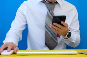 Businessman using his smartphone to send a text message photo