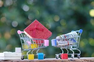 concepto de compras en línea. carrito de compras con moneda en la mesa foto