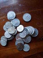 Indonesia, January 2022 - A man holding Indonesian coins or uang receh photo