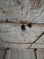 old black lamp fittings against the background of the house ceiling made of woven bamboo. dirty light fittings. photo