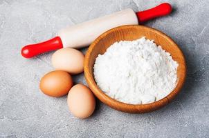 ingredientes para hornear - harina, huevos y alfiler foto