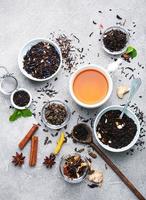 Cup of tea with aromatic dry tea in bowls photo