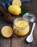 Lemon curd in glass jar with fresh lemons photo