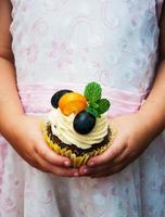 Little girl holding cupcake photo