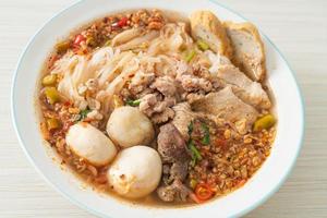 noodles with pork and meatballs in spicy soup photo