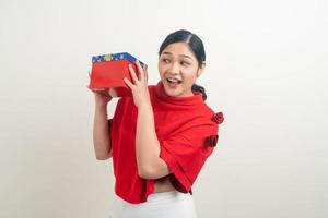 happy Asian woman wearing red shirt with gift box on hand for Christmas festival photo