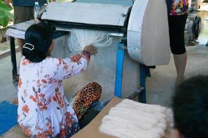 Back view of an unrecognizable woman producing rice noodels. Vietnam photo