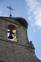 Church tower with a stork nest and the stork in it, seen from below. Rural area or Soria, Spain. photo