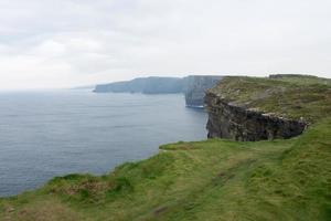 hermosa costa verde en moher, irlanda. acantilados en un día lluvioso. foto