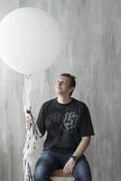A man holding an inflatable ball on a gray background.