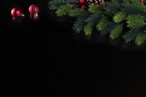 christmas black background with spruce branch and christmas tree toy ball photo