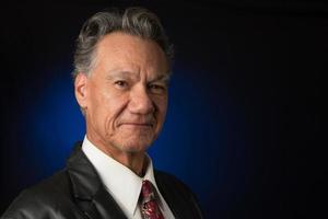 Portrait of a Mature Confident Professional Business man Against a Dark Background photo