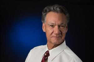 Portrait of a Mature Confident Professional Business man Against a Dark Background photo