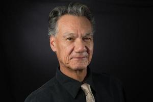 Portrait of a Mature Confident Professional Business man Against a Dark Background photo