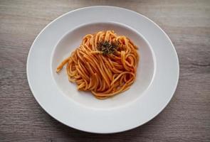 Delicious Italian Spaghetti with tomato sauce on wooden background. Bologna, Italy photo