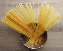 Raw Italian Spaghetti in a bowl on wooden background photo